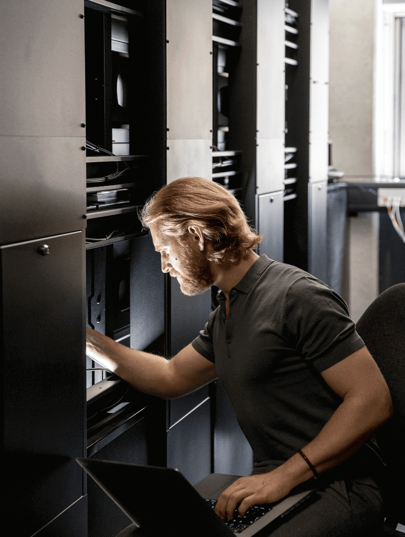 Man looking in server cupboard