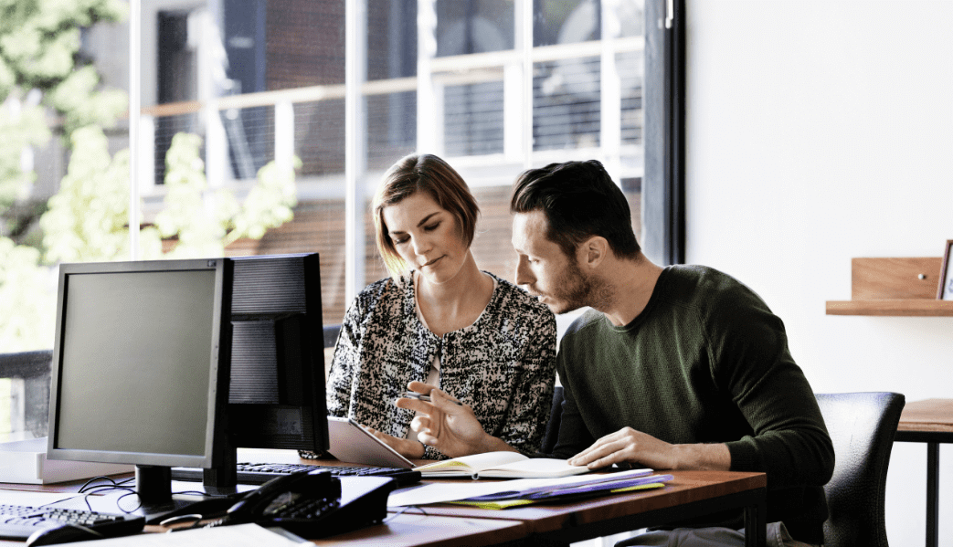 Woman and man comparing notes at a desk