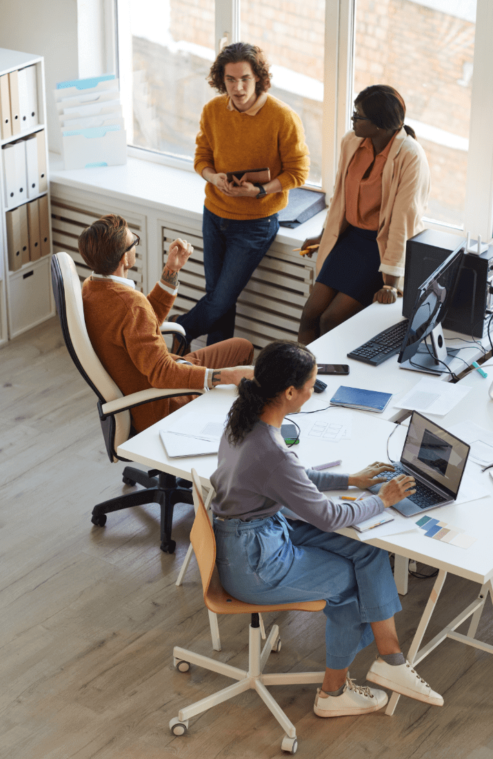 Group of people standing round a desk