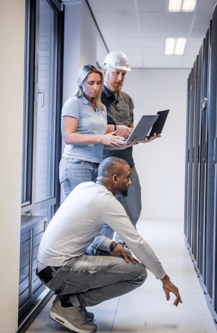 three people looking at server cupboards