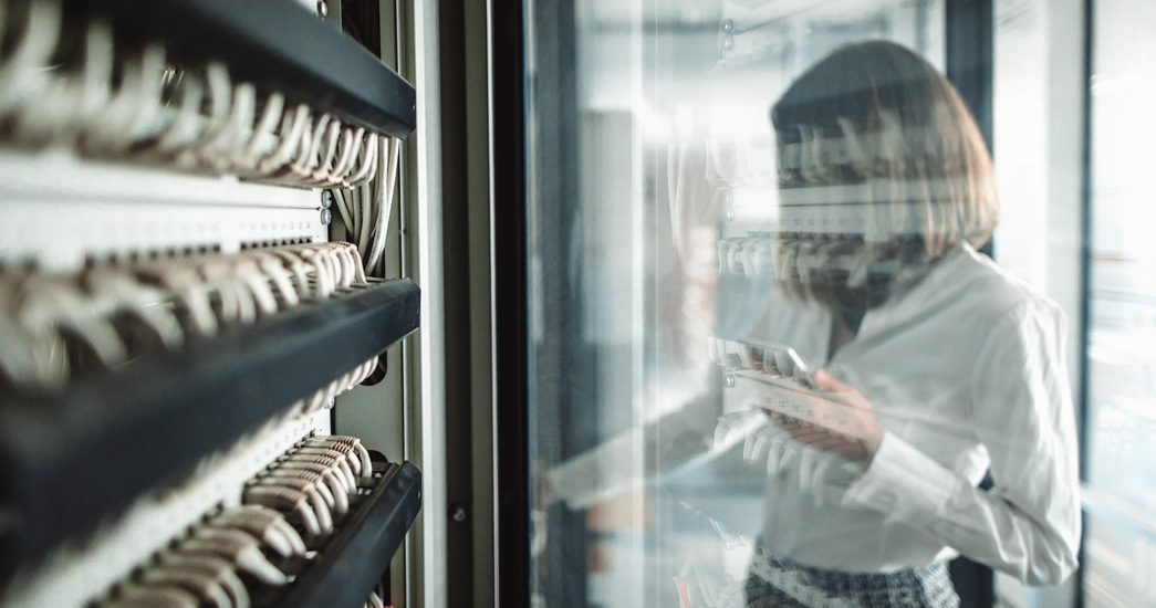 Woman working with data centre network racks