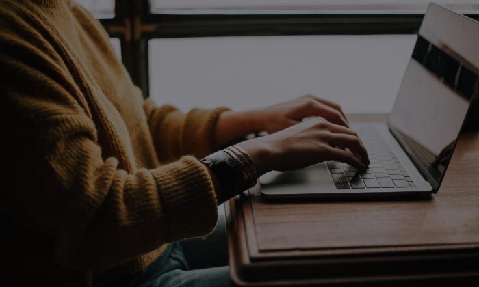 Hands typing on a laptop