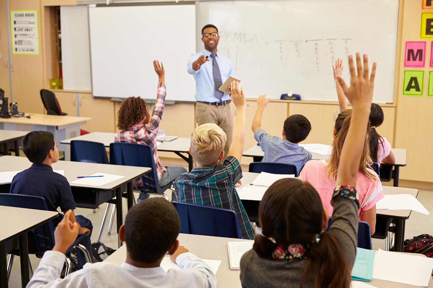 School children with their hands up