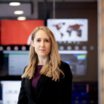 Woman standing in front of cyber lab in a purple top and black blazer